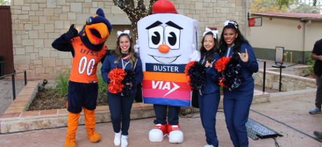 VIA's Buster Mascot poses with the Rowdy mascot and students.