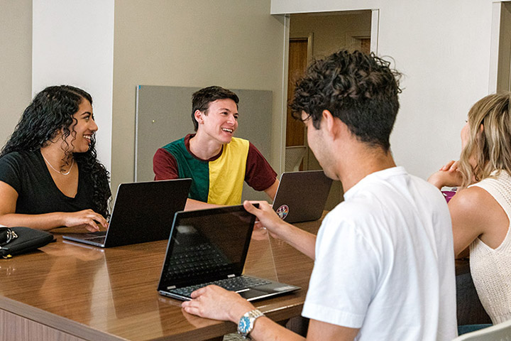 Students sitting in a study room table with their laptops