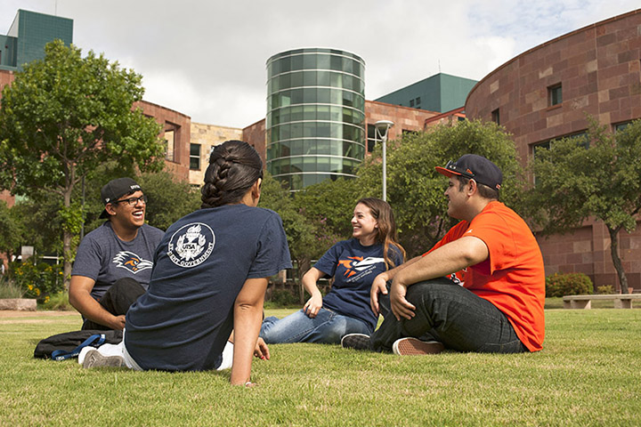 Students talking while sitting on the grass