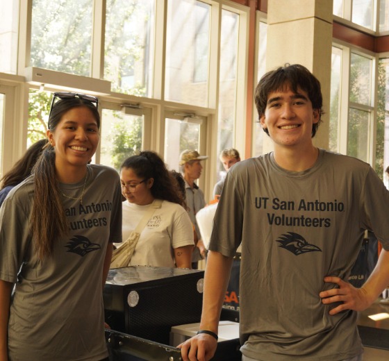 Volunteers at a previous UT San Antonio move-in smiling and wearing UT San Antonio volunteer shirts.